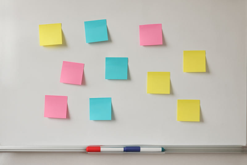 tableau blanc avec post-its et marqueurs